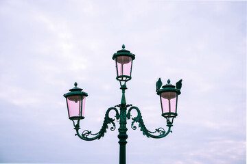 Fototapeta na wymiar Pigeons sitting on a pretty designed Venice street lamp