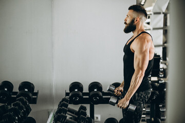 Fototapeta na wymiar Handsome man bodybuilder doing workout at gym