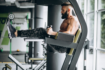 Handsome man bodybuilder doing workout at gym