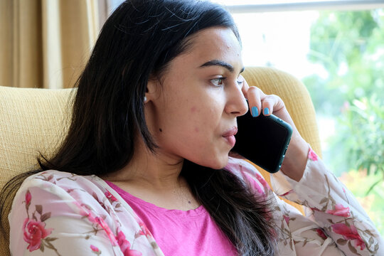 Closeup shot of a young girl talking on the phone
