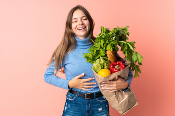 Young Lithuanian woman holding a grocery shopping bag smiling a lot