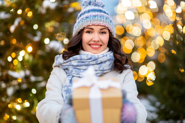 winter holidays, celebration and people concept - happy smiling woman with christmas gift over...