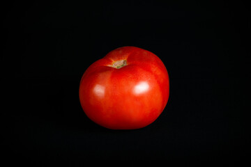 Fototapeta na wymiar Tomate fresco, fondo negro.
