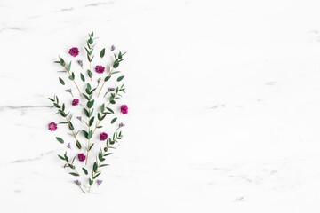 Flowers composition. Purple flowers and eucalyptus leaves on marble background. Flat lay, top view