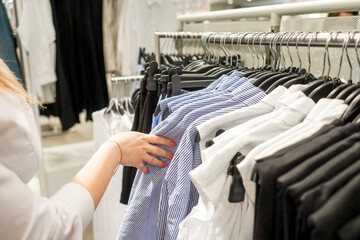 Woman in the mall chooses a blouse.