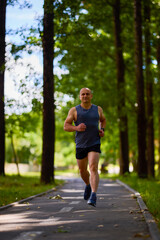 Man running in nature through the park, sports in the city.