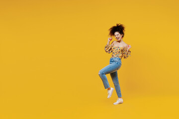 Fototapeta na wymiar Full length young happy excited fun trendy fashionable woman 20s with culry hair wearing casual clothes do winner gesture isolated on plain yellow background studio portrait. People lifestyle concept