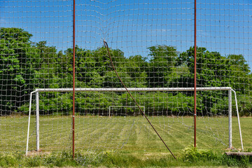 Soccer goal with net in rural field with grass