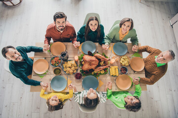 Top above high angle view portrait of adorable cheerful family holding hands eating homemade dish at home indoors