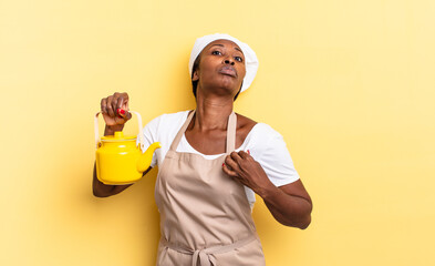 black afro chef woman looking arrogant, successful, positive and proud, pointing to self. teapot concept