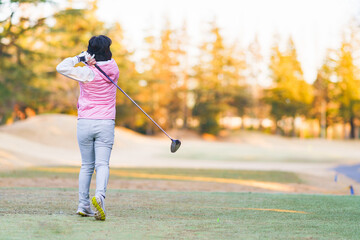 Japanese middle aged woman playing golf in autumn
