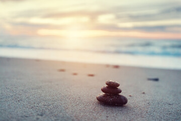Zen stones on calm beach at sunset