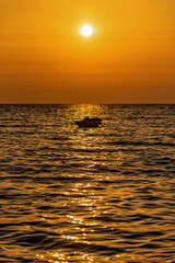 Fototapeta na wymiar A boat at sunrise on the Adriatic Sea