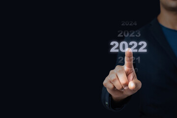 Businessman pointing business calendar happy new year 2022 , Business concept.