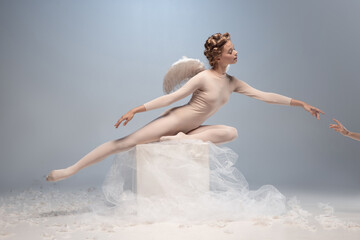 Naklejka premium Young and graceful ballet dancer, ballerina dancing isolated on white gray studio background. Art, motion, action, flexibility, inspiration concept.