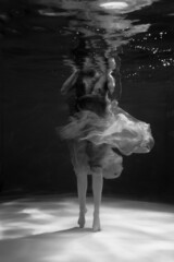 Plakat Black and white photographs where a beautiful girl poses in the water. She looks like a mythical mermaid