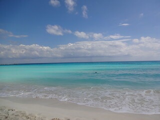 Fototapeta na wymiar Blue sea and the sandy beach of Cancun in Mexico
