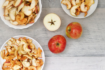 three apples and three plates with dry apples on the table