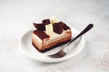 Slice of chocolate mousse cake on a plate, selective focus