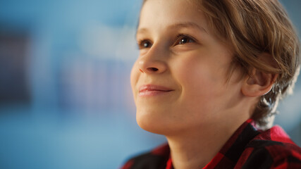 Portrait of a Bright Young Boy Being Concentrated, Looking into the Distance and Thinking About Something in Cozy Room at Home. Cute Teenager with Brown Eyes is Happy and Smiles.
