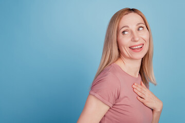Obraz premium Portrait of sweet nice young woman hear funny joke start laugh touch hand chest isolated over blue color background