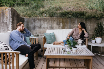 Interracial couple relaxing on patio in summer