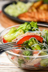 Sauteed vegetable salad with broccoli, asparagus, sweet pepper and cellophane noodles or fensi noodles in a glass bowl