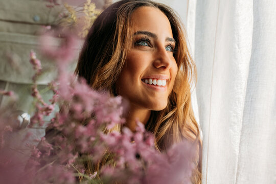 Stylish teen girl smiling while looking through window