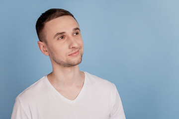Fototapeta premium Portrait of attractive minded happy young man dreaming about smth look empty space isolated over blue color background