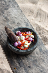 Flat portrait photo of cayenne pepper, garlic, and shallot, on a wooden board