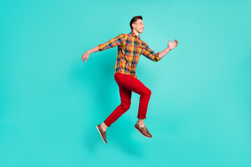 Fototapeta na wymiar Full size profile photo of funky brunet young guy jump wear shirt turquoise sneakers isolated on teal background