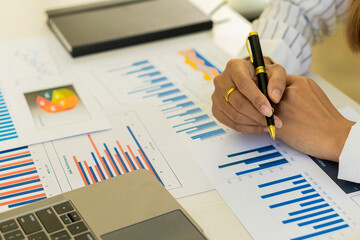 Businessman holding a pen pointing to an analysis graph, investment planning, work projects and business discussion strategies.