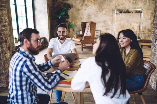 Happy diverse colleagues playing group game in modern workspace