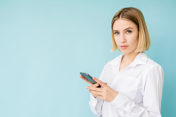 Mobile communication. Elegant woman. Business chat. Advertising background. Pretty lady office look holding smartphone isolated blue copy space.
