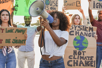 Young multiracial people demonstrate on the street with banner for the climate change - Millennial...
