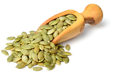 raw pumpkin seeds in the wooden scoop, isolated on white