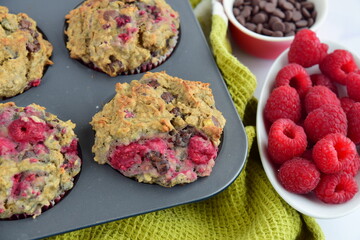Freshly baked raspberry banana chocolate chip muffins on muffin pan