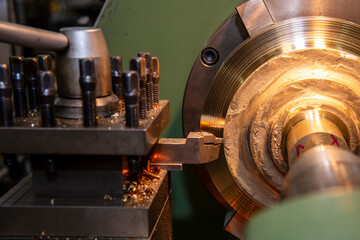 The lathe machine rough cutting the brass material parts .