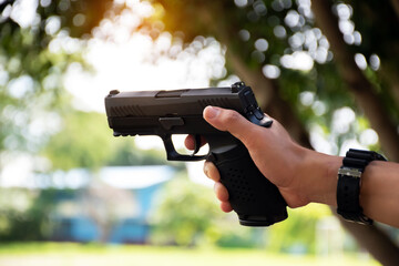 Automatic black 9mm pistol holding in hands aming to the shooting tar. concept for sports,...
