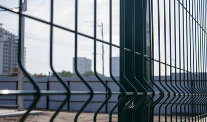 Steel lattice green fence with wire. Fencing. Grid industrial wire fence panels, pvc metal. Installation of sectional fencing. Welded mesh fence. Installation of a grid for fencing the territory.