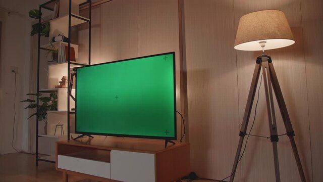 Shot Of A Tv With Horizontal Green Screen Mock Up. Cozy Evening Living Room At Home
