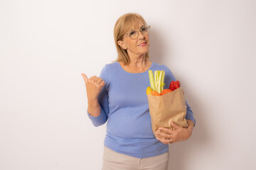 Senior shopping woman with grocery items . Isolated over white background.