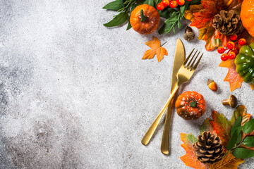Autumn table. Thankksgiving food concept. Gold cutlery and autumn decorations at stone kitchen table. Top view with copy space.