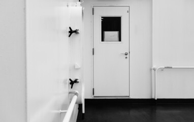 clean white modern vessel ship closed entrance door black deck floor with air vent grille and valves on the wall