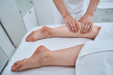 Massotherapist giving a deep tissue leg massage