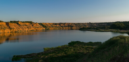 Fototapeta premium Mountain lake in the light of the setting sun. Beautiful natural landscape. Horizontal photo.