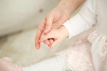 the small hand of the child in the mother's hand