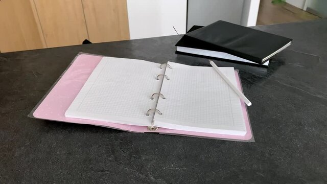 Hand writes with a pencil in a notebook