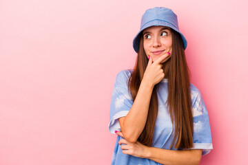 Fototapeta premium Young caucasian woman isolated on pink background looking sideways with doubtful and skeptical expression.