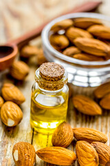 spa with almond oil in organic cosmetic set on wooden background